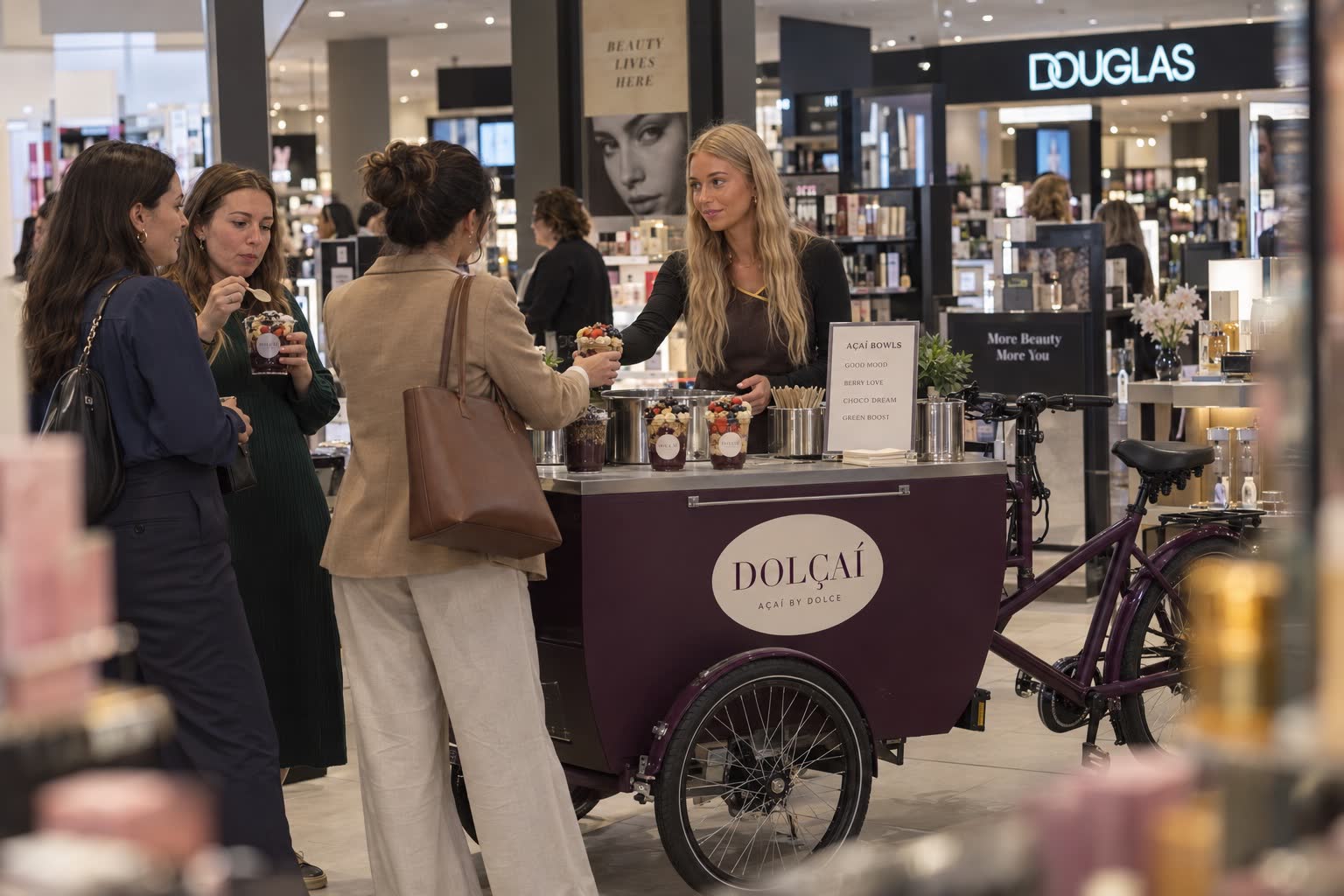 Dolçaí-Mitarbeiterin serviert Açaí Bowls an Gäste bei einem Beauty-Event